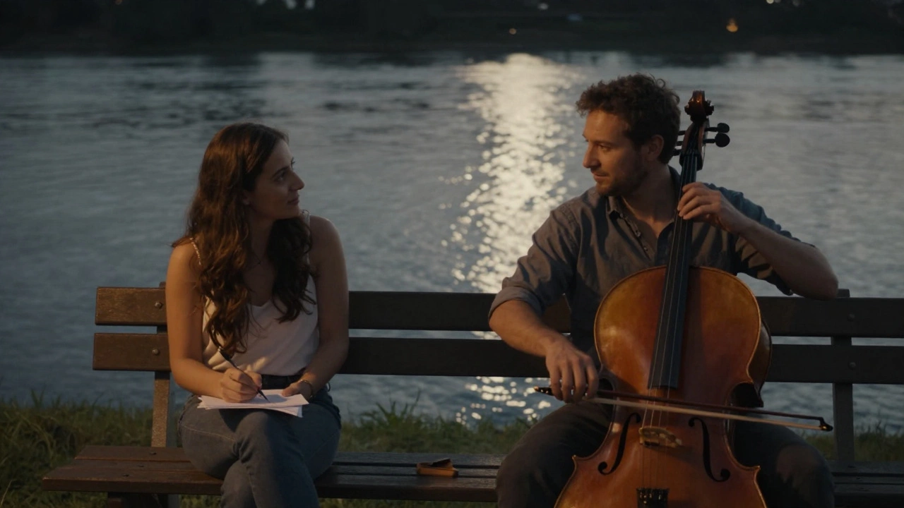 A man plays cello by the river at night while a woman draws on a napkin, sharing a quiet, unspoken moment under moonlight.